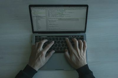 Close-up view of a programmer coding on a laptop, showcasing modern software development.