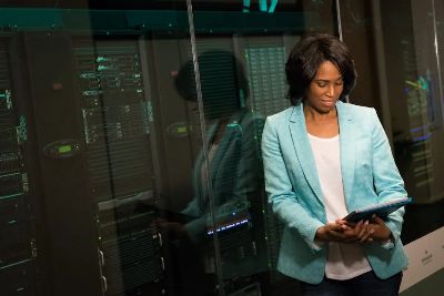 Female IT professional examining data servers in a modern data center setting.
