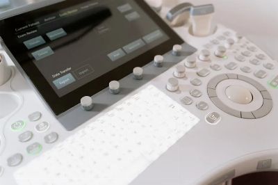 Detailed view of a medical ultrasound machine control panel with buttons and screen.