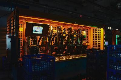 A complex piece of machinery in a dark industrial setting with vibrant lighting.