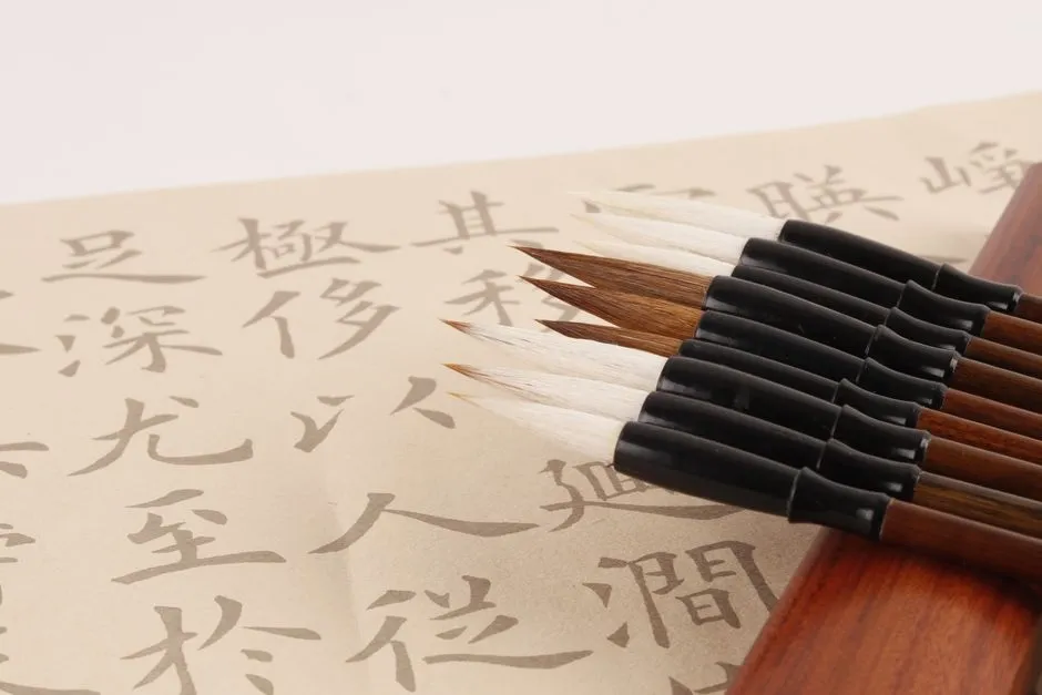 Traditional Chinese calligraphy brushes resting on paper covered in brushed Chinese characters