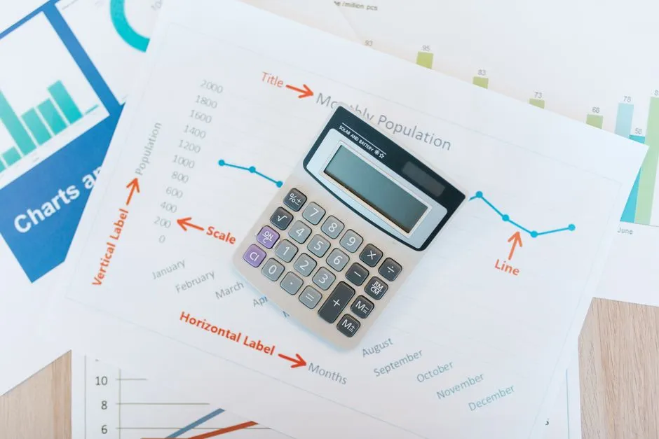 A calculator resting on printed line and bar charts on a desk