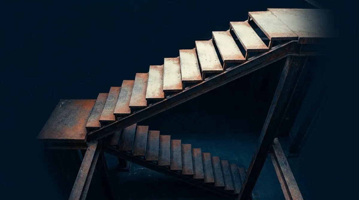 Industrial steel staircase in low light with steps of uneven prominence receding into shadow — illustrating a price ladder whose rungs have pulled apart.