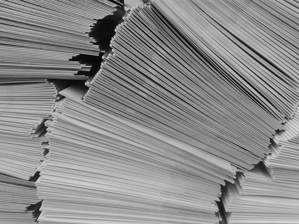A dense stack of thousands of white envelopes
