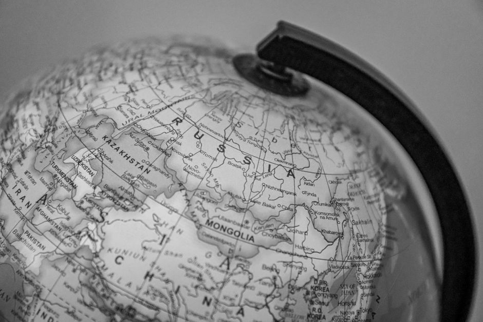 Black and white close-up of a globe focusing on Russia and surrounding countries.