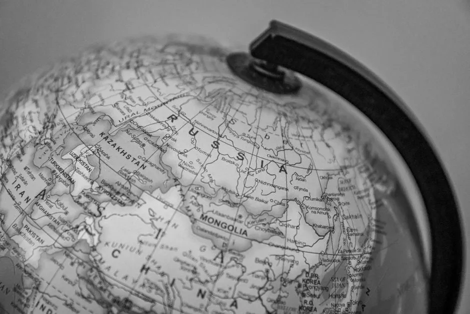 Black and white close-up of a globe focusing on Russia and surrounding countries.