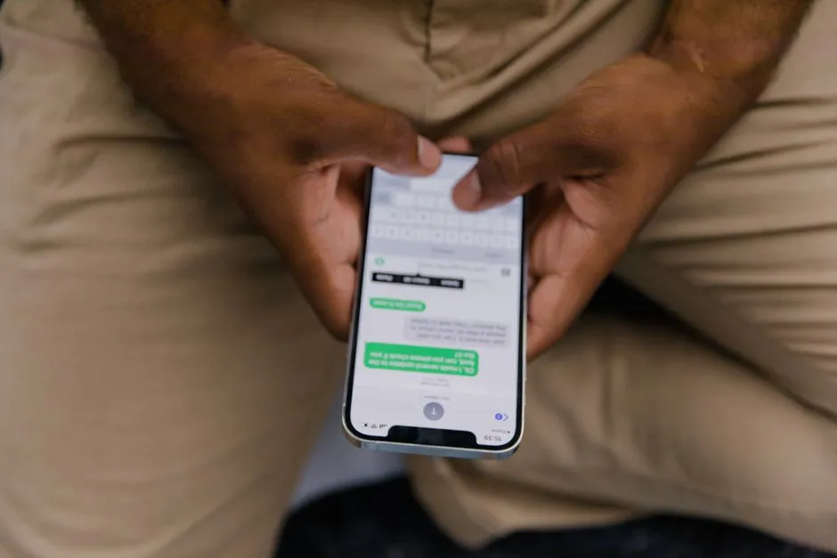 Hands holding a smartphone open to a chat conversation, the kind of exchange an on-device scam detector would analyse