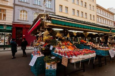 Explore a lively outdoor market stall with assorted fruits and vegetables, perfect for a local shopping experience.