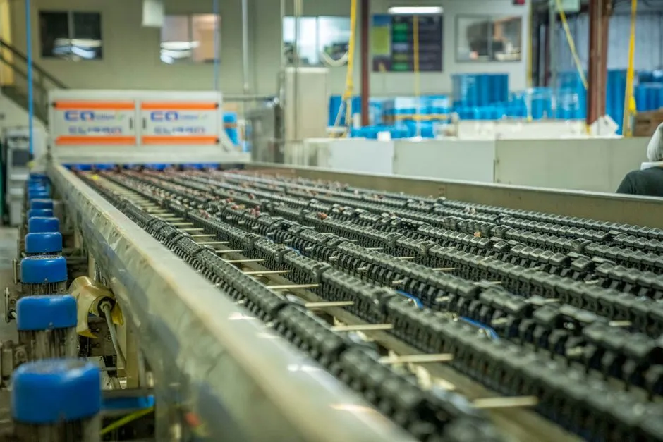 Rows of components moving along a factory conveyor line, illustrating a report on infrastructure for running coding agents as a repeatable pipeline.