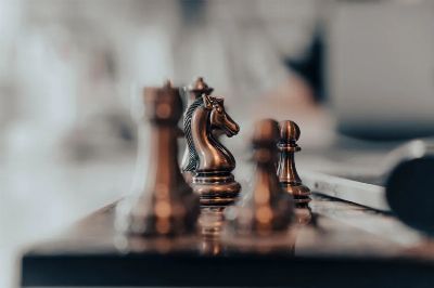 A detailed close-up of chess pieces on a board, highlighting the knight in warm tones.