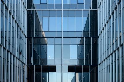 Contemporary building facade with reflective glass windows in an urban environment.