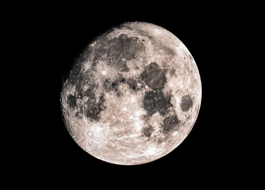A near-full Moon photographed against black sky, its craters and dark maria clearly resolved