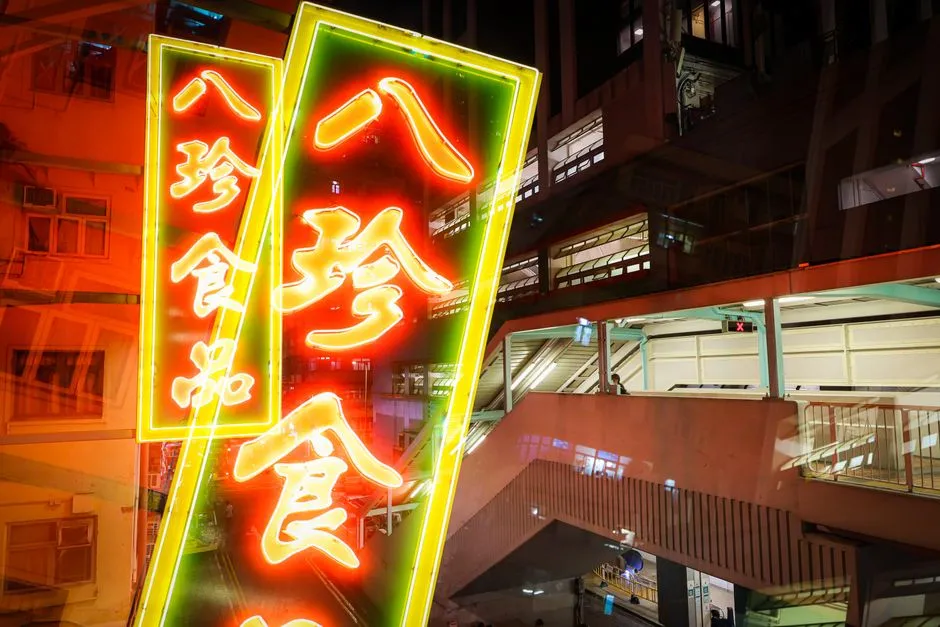 Illuminated Chinese neon shop signs above a Hong Kong street at night