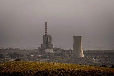 A coal-fired power plant emits smoke on an overcast day, highlighting energy and environmental issues.