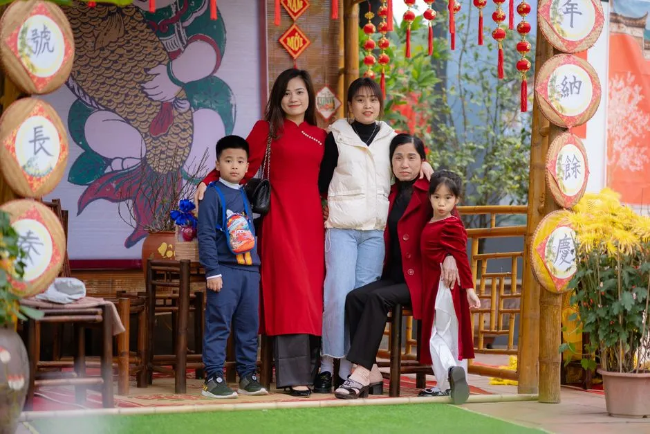 A family of three generations posing for a photograph at a Lunar New Year display