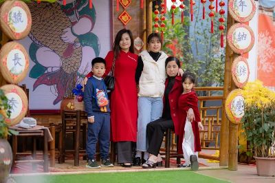 A family poses joyfully during a traditional Lunar New Year celebration.
