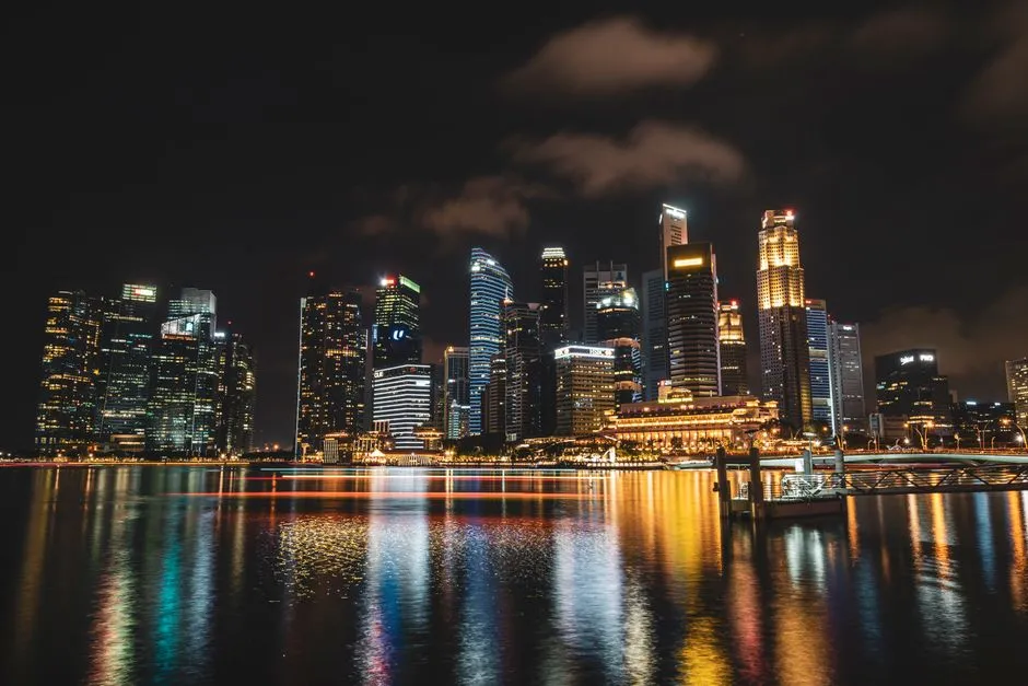Singapore's financial district lit up at night, reflected in Marina Bay