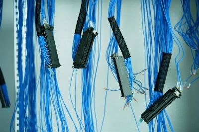Close-up of blue ethernet cables hanging in a data center, highlighting technology connections.