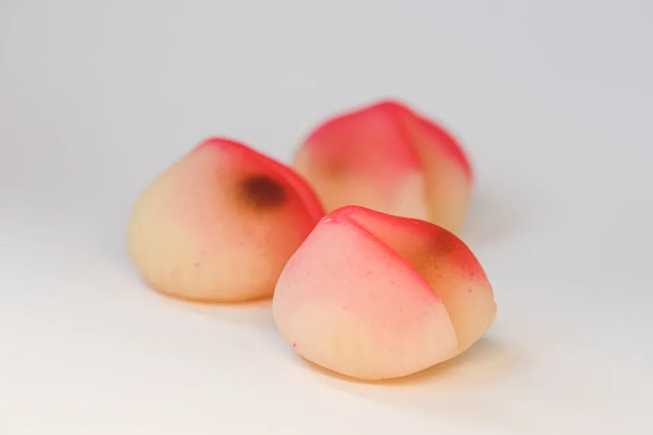 Three peach-shaped longevity buns, a traditional birthday food