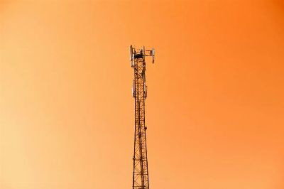 Radio mast silhouetted against a vibrant orange sky in Adana, Türkiye.