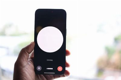 Close-up of a hand holding a smartphone displaying a voice assistant interface.