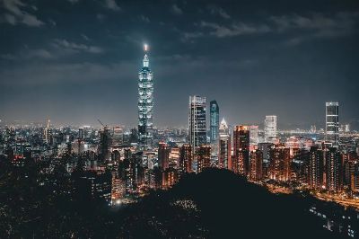 Night view of the Taipei skyline featuring the illuminated Taipei 101 amid modern skyscrapers.
