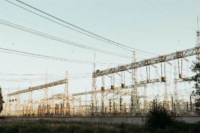 A wide view of an industrial electrical substation with power lines and towers outdoors.