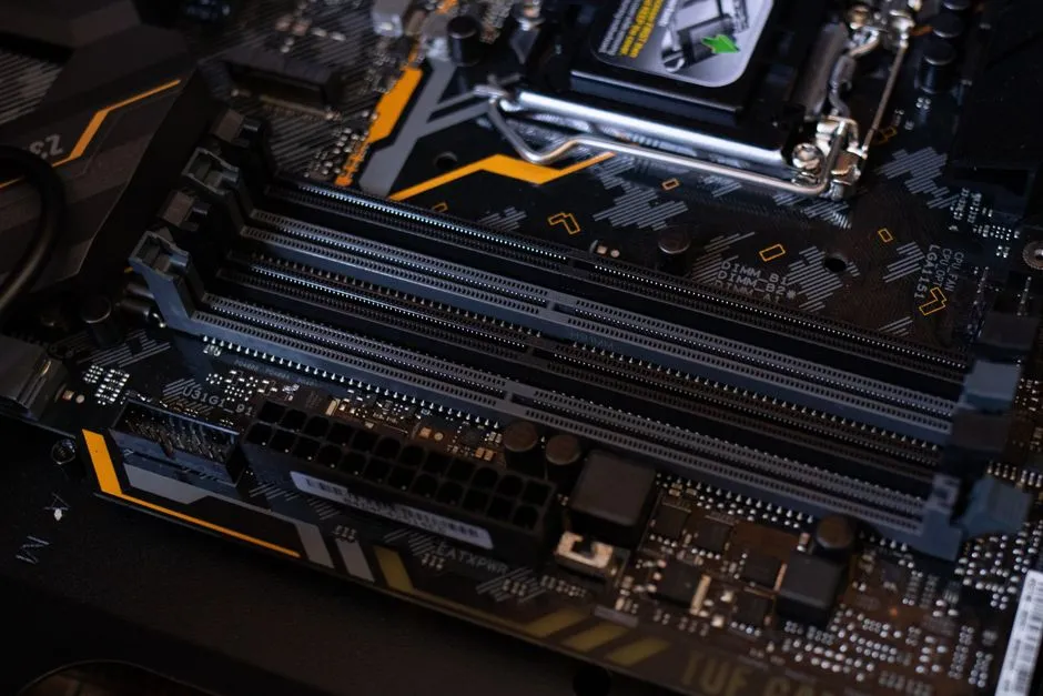 Four empty memory slots on a dark motherboard, lit from one side, with the CPU socket visible behind them