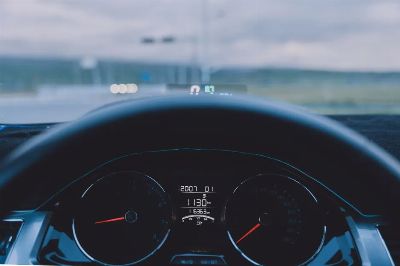 View from inside a car showing dashboard and steering wheel on an open road.