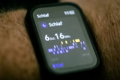 Close-up of a smartwatch displaying sleep tracking data in German.