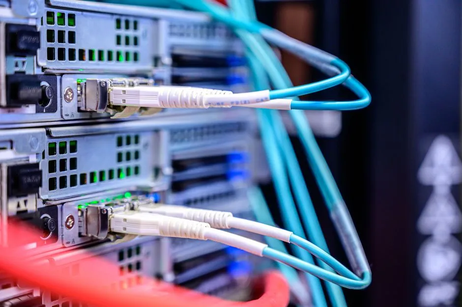 Fibre optic patch cables plugged into the front panels of rack-mounted servers, photographed close up