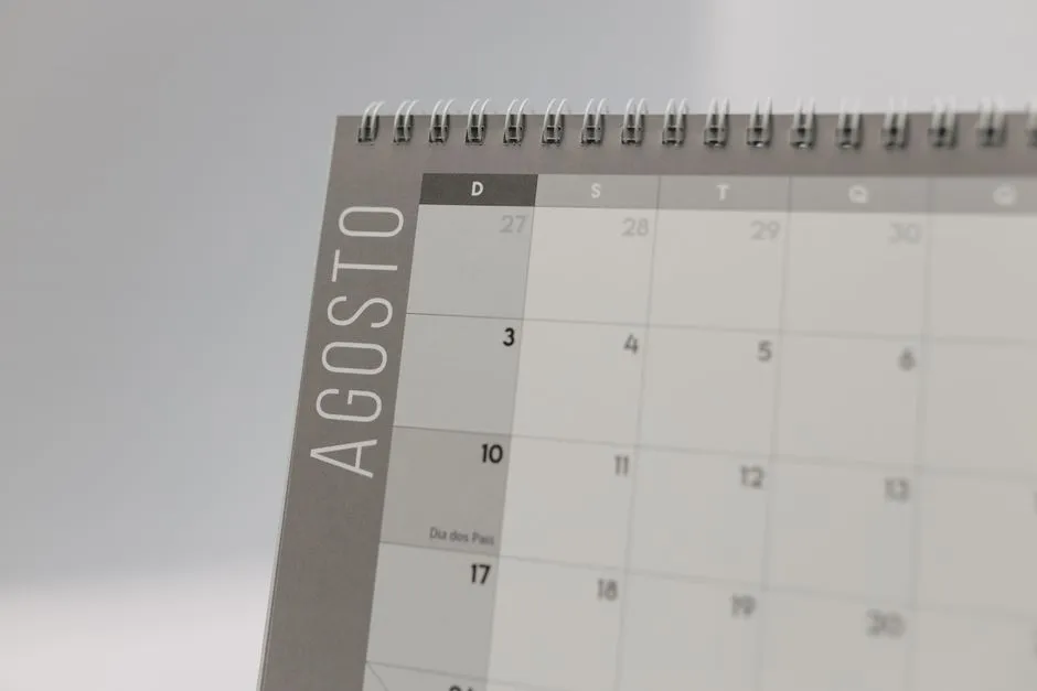 A desk calendar open at a month, its dates laid out in a grid of numbered cells.