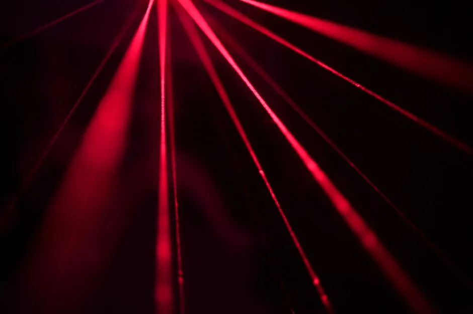 Red laser beams fanning out in a dark room, illustrating a report on Infleqtion's neutral-atom quantum results.