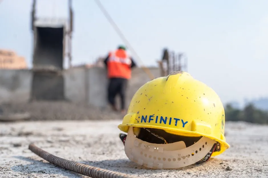 A yellow safety helmet resting on rubble at a construction site