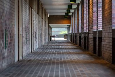 A quiet, empty corridor in Barbican Centre, London with brick walls and ceiling lights.