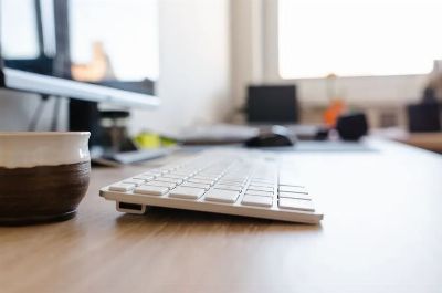 Modern office desk setup featuring a computer keyboard and monitor, ideal for workspaces.