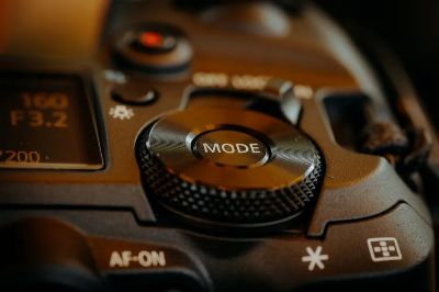Detailed view of DSLR camera mode dial and buttons, showcasing photography settings.