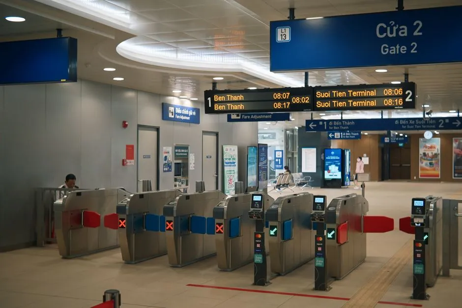 A row of metro fare gates, some displaying a green tick and others a red cross, beneath station departure signage