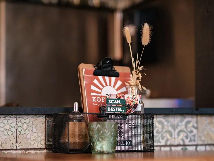 A card on a restaurant table inviting diners to scan a code to order.