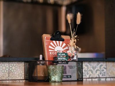 Inviting cafe table with rustic decor, menu card, and ambient candlelight in a cozy restaurant.