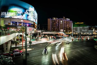 Dynamic night scene on the Las Vegas Strip featuring vibrant lights and busy intersections.