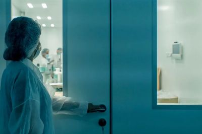 A scientist in protective gear enters a sterile laboratory environment, ensuring cleanliness.