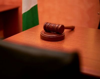 A close-up of a gavel on a courtroom desk representing law and justice.