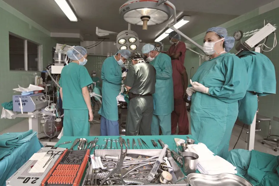Medical team conducting surgery in a sterile operating room with surgical tools on display.