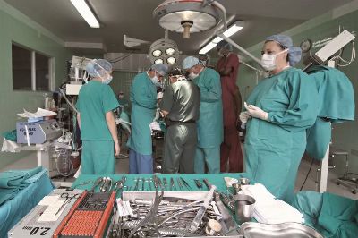 Medical team conducting surgery in a sterile operating room with surgical tools on display.