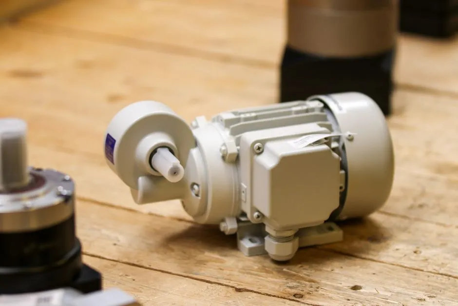 A small industrial gearmotor resting on a wooden workbench, illustrating a report on an on-device AI sensor for monitoring rotating machinery.