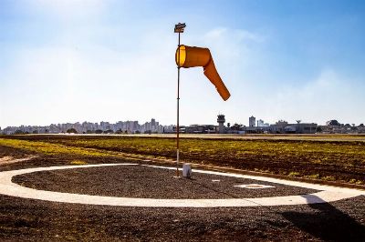 View of a windsock and control tower at Londrina airport highlighting aviation and communication.