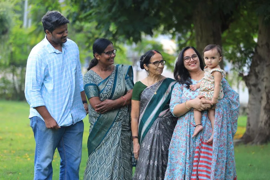 Grandparents, parents and a small child walking together on a lawn