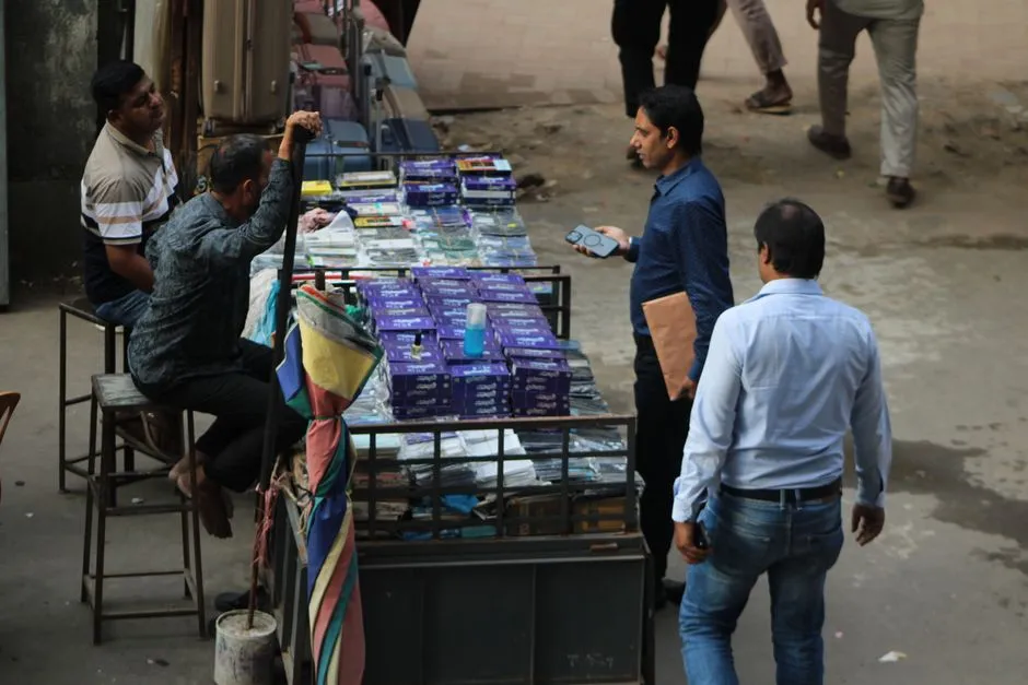 Customers at a street stall selling mobile accessories, the channel through which inexpensive handsets are bought