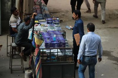 Men browsing mobile accessories at a street market stall.